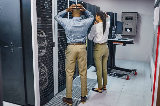 Two IT professionals reacting to a system disaster in a server room