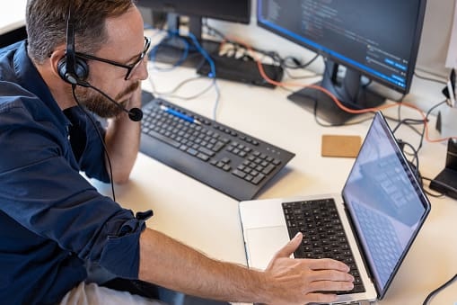 Person using a computer keyboard in a dimly lit workspace
